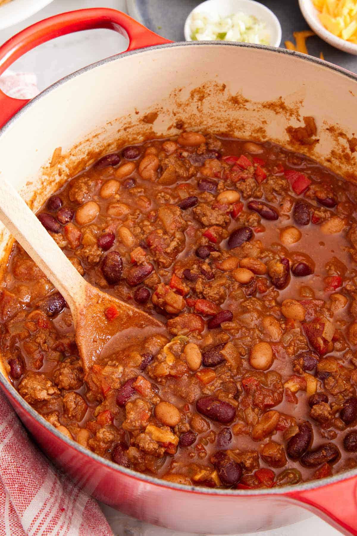 A large pot of finished chili simmering on the stove