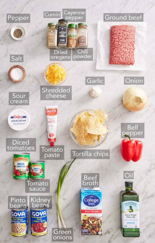 Ingredients needed to make chili laid out on a wooden surface