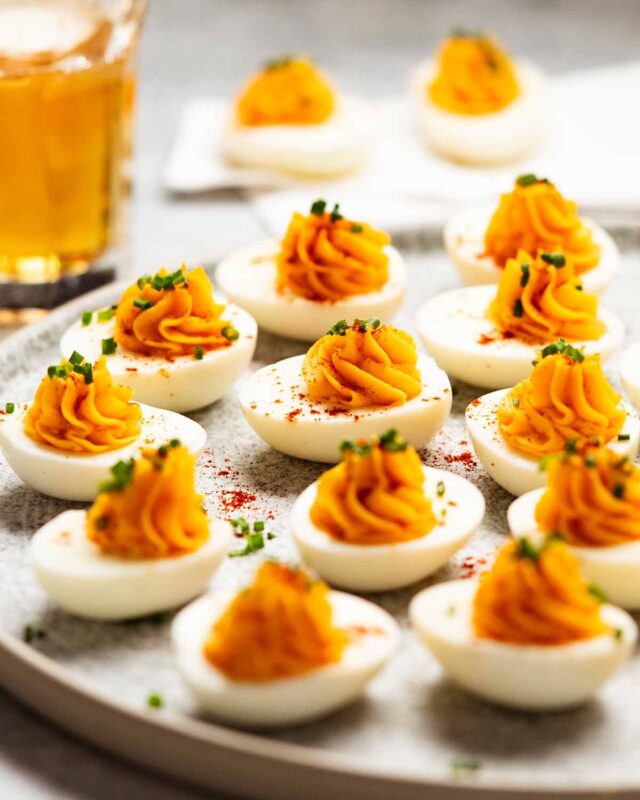 A close-up of a finished deviled egg, perfectly piped and garnished.