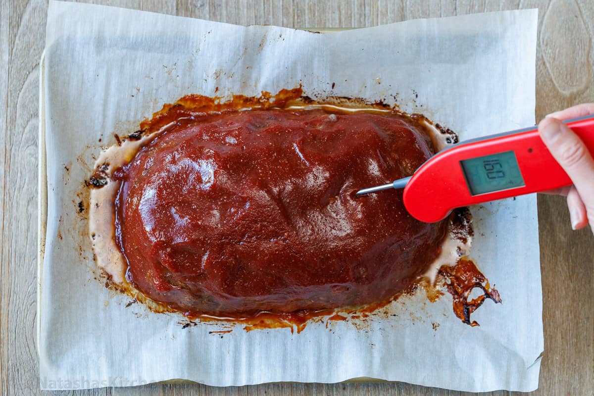 Checking the internal temperature of the meatloaf with a thermometer