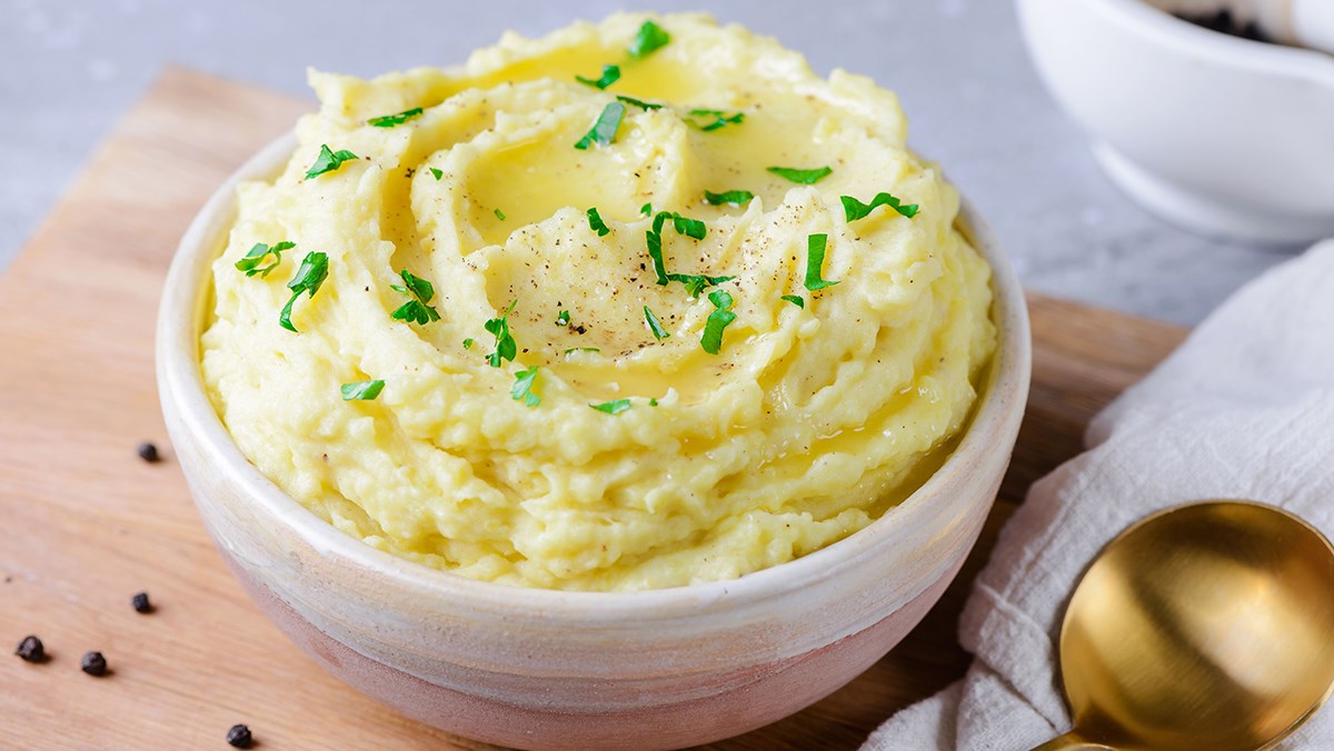 Bowl of creamy mashed potatoes garnished with chives