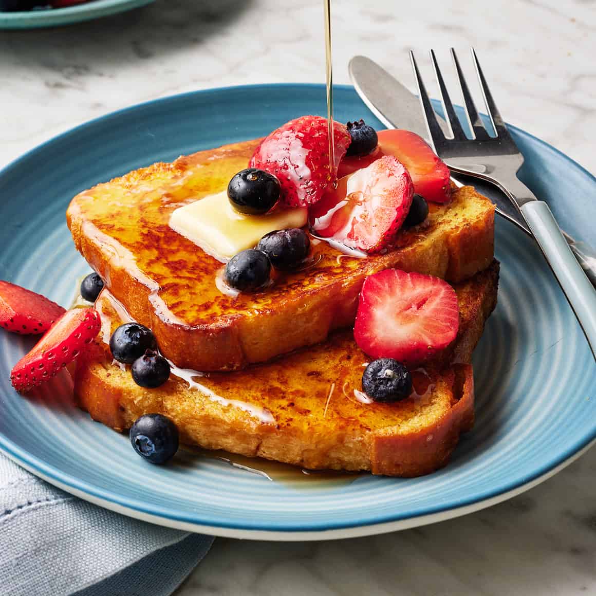 A stack of perfectly cooked French toast on a plate