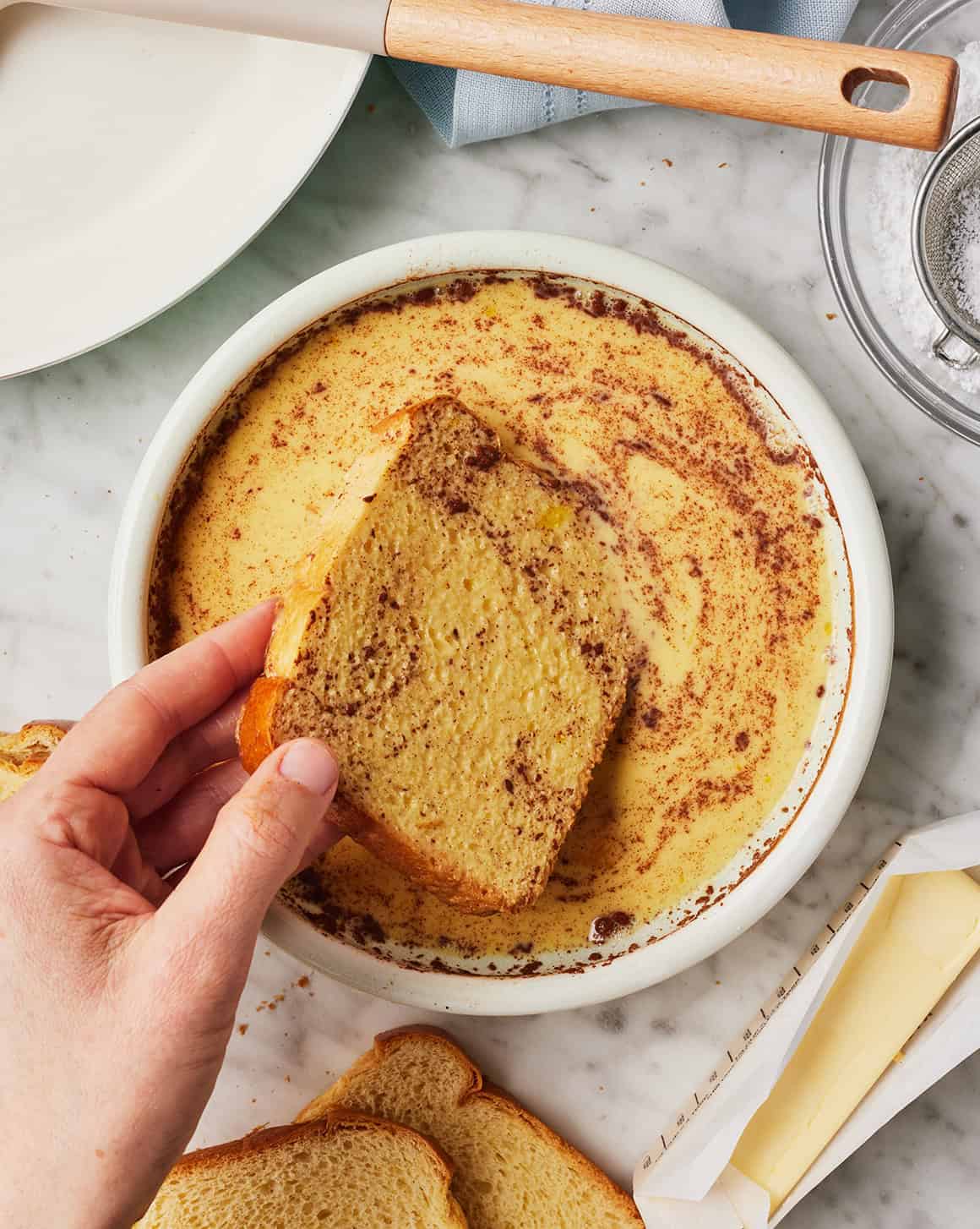 Dipping a thick slice of bread into the egg custard mixture
